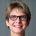 Retrato de una mujer de mediana edad con gafas, sonriendo.